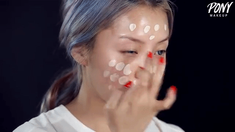 Tapándose la base de maquillaje que tapa el acné